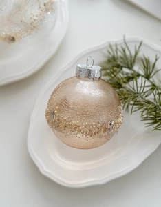 Detailed view of champagne Christmas ornament with crackle glaze and bead embellishments