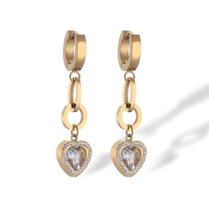 Detailed shot of gold-plated geometric drop earrings with heart pendant and zirconia stones