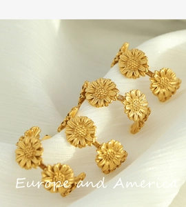 Detailed view of 18k gold daisy flower earrings on elegant white pleated fabric background