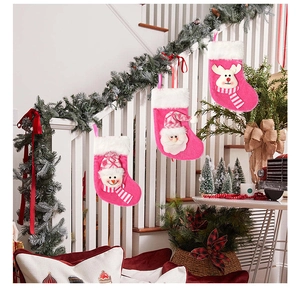 Bottes de Noël roses avec Père Noël, bonhomme de neige et renne sur l'escalier