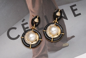 Détails macro des boucles d'oreilles émail vintage avec perles blanches et zircons