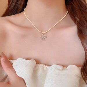 Dettaglio della collana di perle di cristallo giallo con ciondolo a fiore in argento