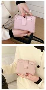 Close-up of pink canvas and PU leather folding wallet held in a natural cafe setting