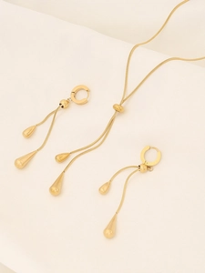 Detailed view of teardrop pendant necklace and matching earrings set in gold titanium steel
