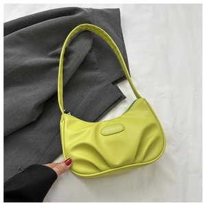 Detail of bright lime green PU leather shoulder bag with stylish pleated texture