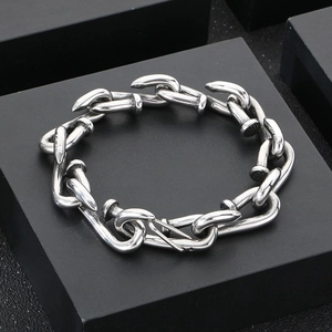 Close-up of interlocking silver nail-shaped links on a square metallic chain bracelet