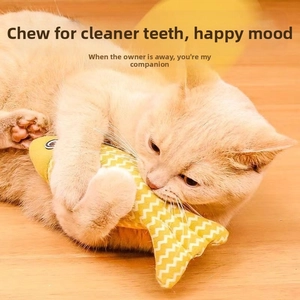 Orange cat hugging and biting a yellow fish-shaped chew toy with white wave patterns