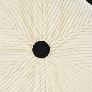 Macro shot of two-tone corduroy baseball cap with stitched top button and texture details