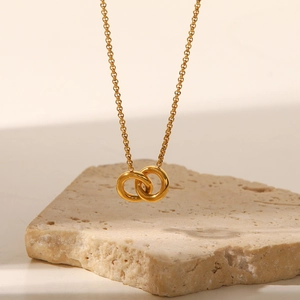 Macro shot of interlocking golden rings pendant on a fine necklace with metallic luster