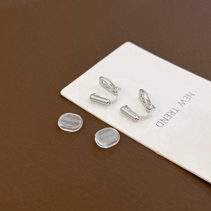 Detail of silver geometric screw-on ear clip converters with clear silicone pads