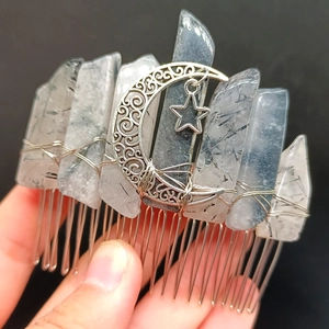 Macro view of handmade star and moon crescent hair comb with natural raw crystal pillars