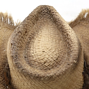 Macro view of woven raffia texture and cowboy hat crown with frayed edge detail