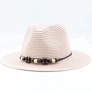 Close-up of pink Panama straw hat featuring black woven cord and two-tone wooden beads