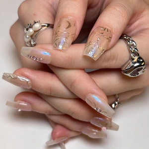 Long trapezoid press-on nails with iridescent star moon patterns and rhinestones