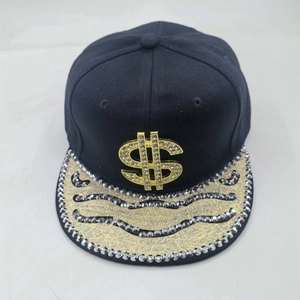Detailed close-up of a black flat brim hat with golden dollar sign and sequined waves