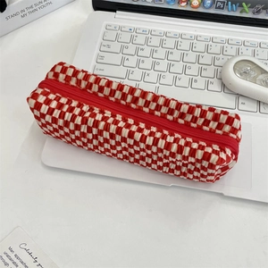 Close-up of red and white checkered knit pouch texture on a white laptop keyboard