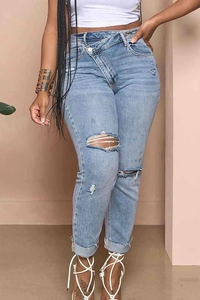 Detail of the light blue ripped jeans showing the asymmetric crossover waist design