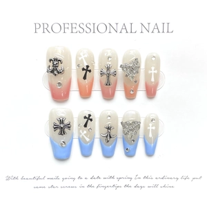 Macro detail of Y2K style press-on nails with metal crosses and silver rhinestones