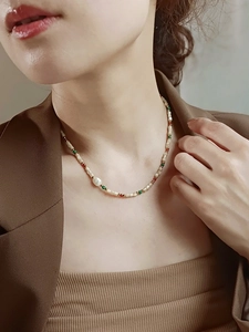 Primer plano de collar de cuentas de colores de lujo con perla de agua dulce en la modelo