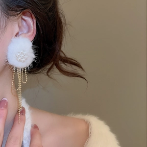 Detail of white pom-pom flower earrings with pearl accents and long golden tassels