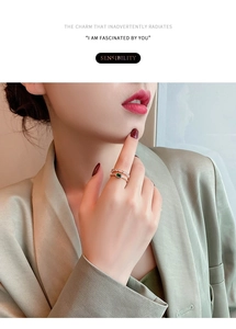 Detail of a luxury double-layer gold ring with green emerald stone and white zircons