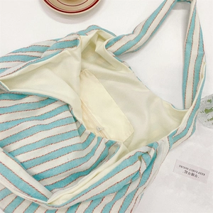 Detail shot of the large canvas tote bag interior with blue stripes and a zipper pocket