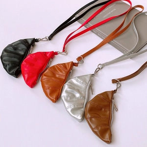Close-up of faux leather croissant neck pouches in five colors with stitch detail