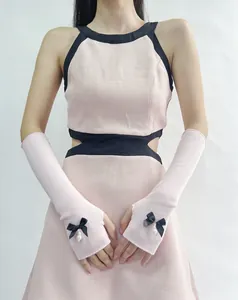 Detail of pink ribbed arm warmers featuring black ribbon bows and pearl accents