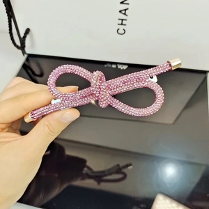 Dettaglio fermaglio per capelli a fiocco rosa con strass scintillanti e clip metallica