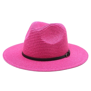 Detail view of woven texture and black faux leather buckle on magenta fedora hat