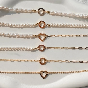 Detail van barok parelketting met gouden hartsluiting en kristallen ring hanger