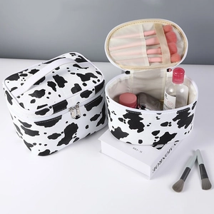 Large waterproof makeup bags with cow print showing open and closed storage states