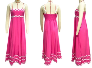 Close-up of fuchsia maxi dress featuring white wavy lace trim and elastic smocking back
