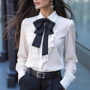 Elegant white long sleeve blouse featuring a black bow tie and ruffle trim detailing