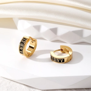 Detailed macro view of 18K gold-plated stainless steel hoop earrings with black enamel