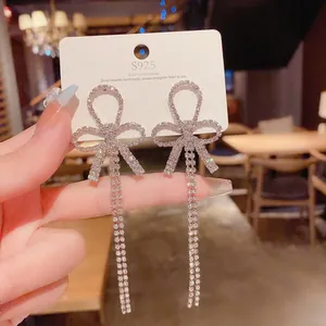 Detail of S925 silver needle bow knot earrings with dangling long rhinestone tassels