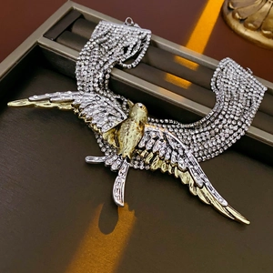 Detailed view of rhinestone swallow pendant and multi-layer chain tassels on silver necklace