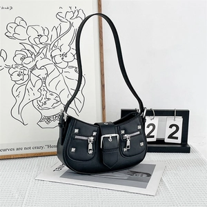 Retro black crescent underarm bag with silver studs and metal buckles in a stylish setting