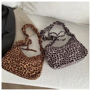 Brown and grey leopard print crescent bags with pleated shoulder straps on flat lay