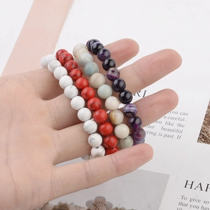 Close-up of 8mm natural stone beaded bracelets including marble and agate on a hand