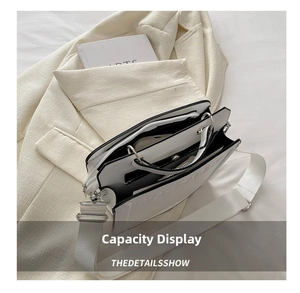 Detail showing spacious interior compartments of a white tote bag with contrast piping