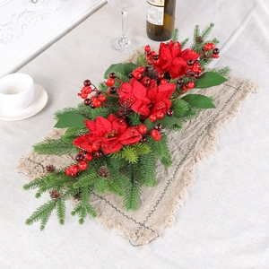 Weihnachtliche Tischdeko mit roten Weihnachtssternen, Tannennadeln und Beeren