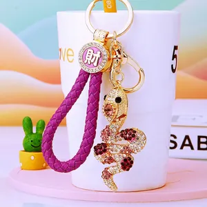Detail of purple braided rope zodiac snake keychain with gold-plated rhinestone charm