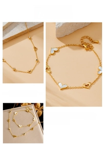 Detail view of gold heart necklace and bracelet set with white mother of pearl inlays