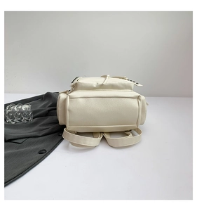 Bottom view of off-white PU leather backpack with cross rivets and lychee texture