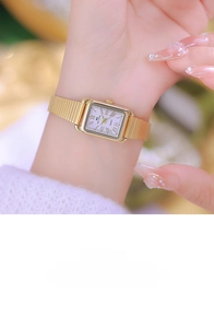 Close-up of gold square watch with purple dial and elastic snake chain strap on wrist