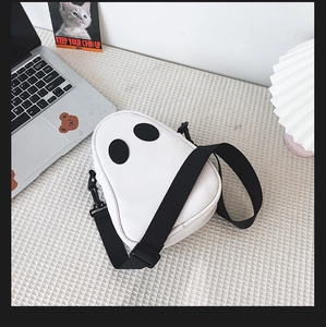 Detail shot of the spooky ghost shoulder bag made of white PU leather with black eyes