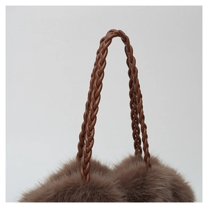 Detail of woven brown leather handle and soft plush texture on the shoulder bag