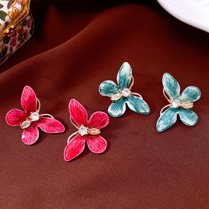 Détail de boucles d'oreilles papillon vintage avec incrustation de zircon et émail coloré