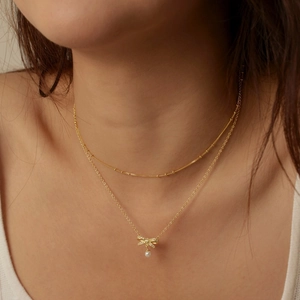 Elegant gold S925 sterling silver layered necklace with bow pendant and pearl detail